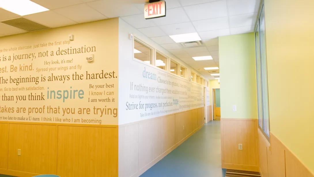 empty light filled hallway with inspirational quotes written on the wall