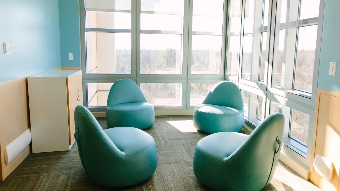empty small corner room with windowed walls and four comfortable chairs 
