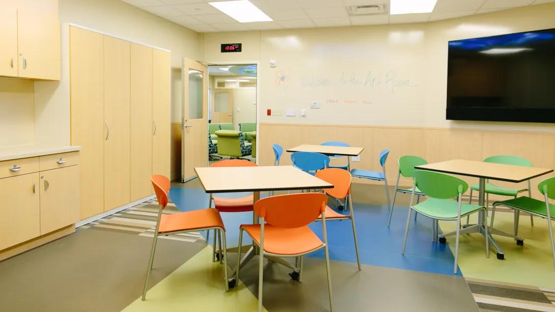 empty art room with brightly colored tables and chairs,