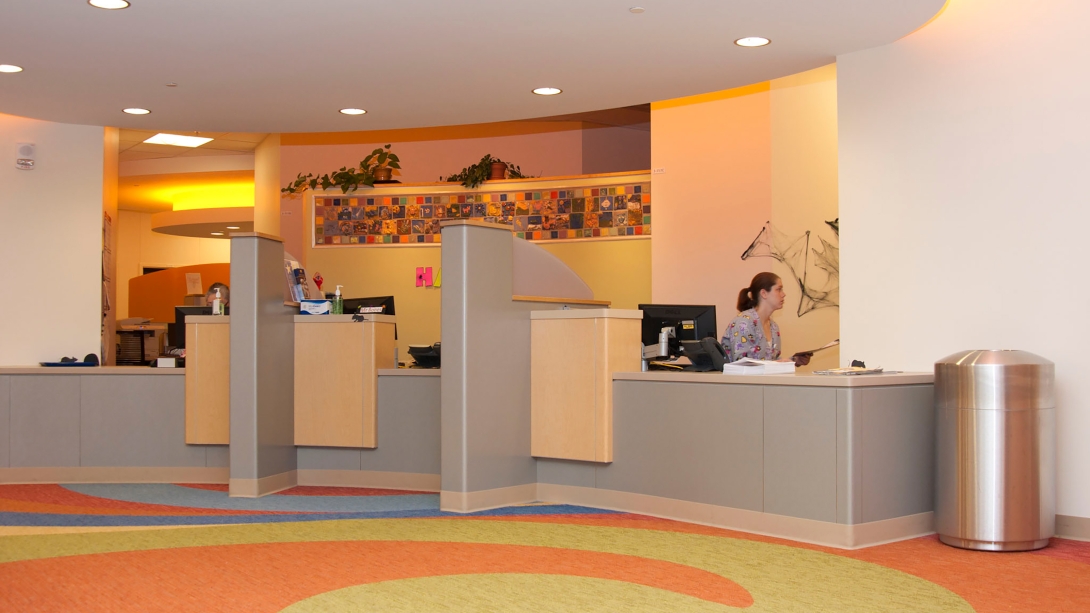 pediatric clinic check-in counter with colorful floor and wall mosaic