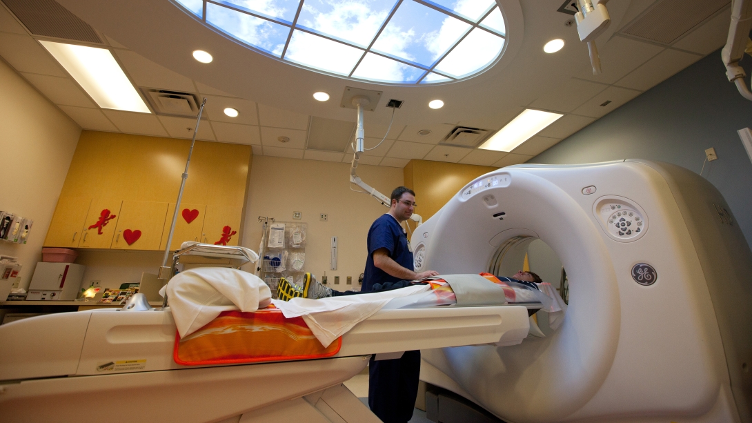 Technician lowering child into an MRI machine. 