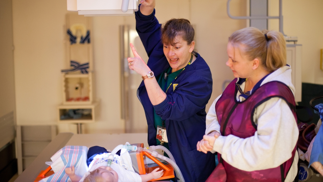 Technician lowers the x ray on top of the baby 