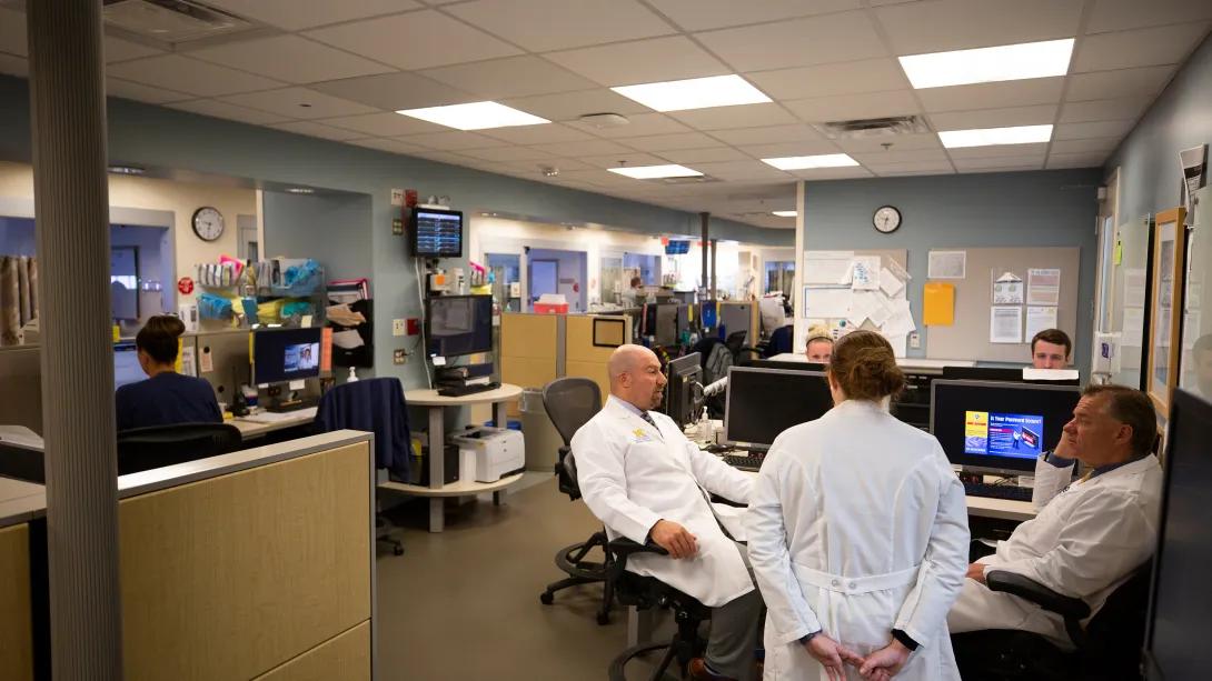 doctors gather in workstation with computers 