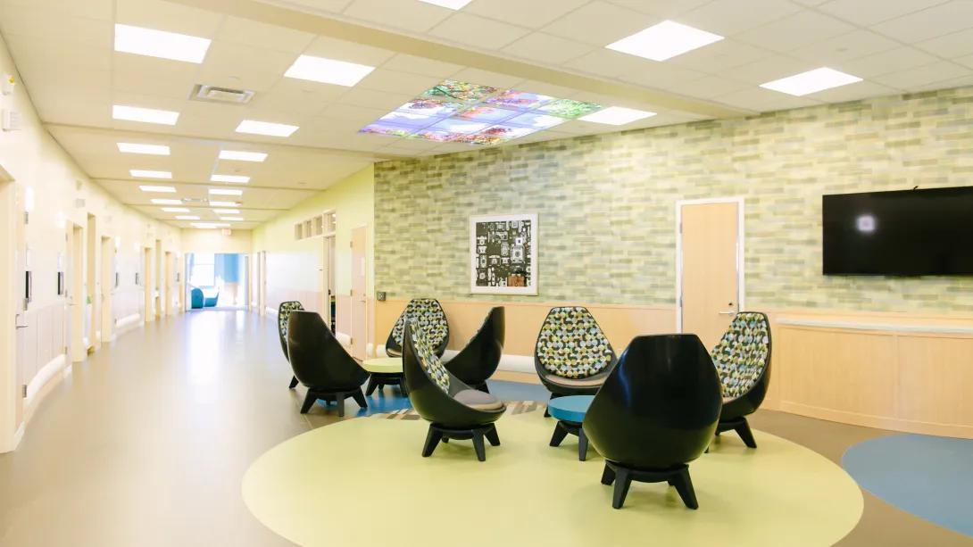 empty hallways with patient room off to the sides and egg chairs situated in groups