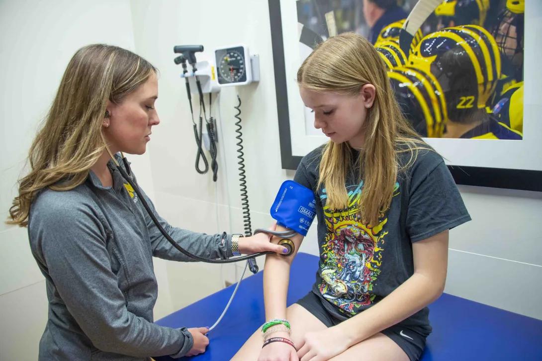 doctor takes vitals and blood pressure on patient 