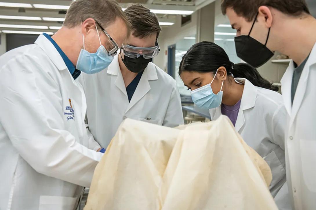 Doctors in surgery wearing masks looking down at patient