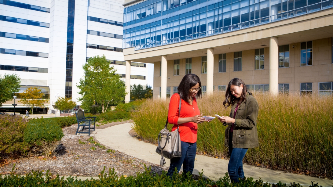 Two girls standing outside a campus building