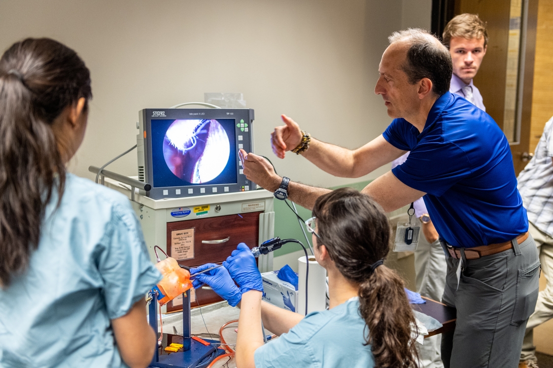 Otolaryngology students practice with a machine in the simulation lab
