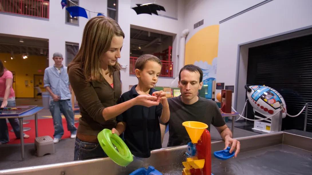 A man and woman working on a puzzle with a child
