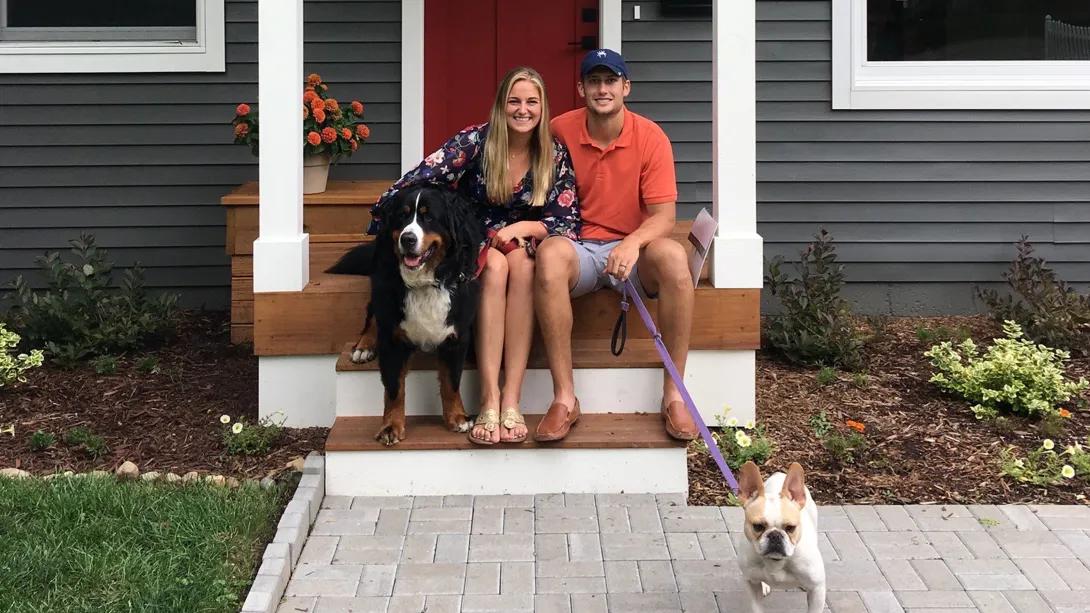 Two people sitting on the front step of a home