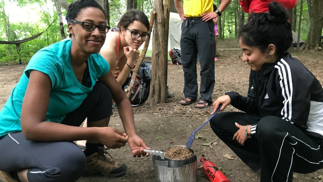 Students cooking at camp in the woods