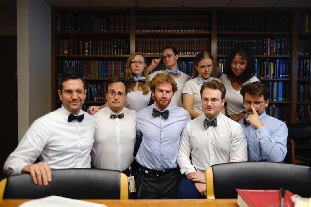 a group of people wearing bowties posing for a photo