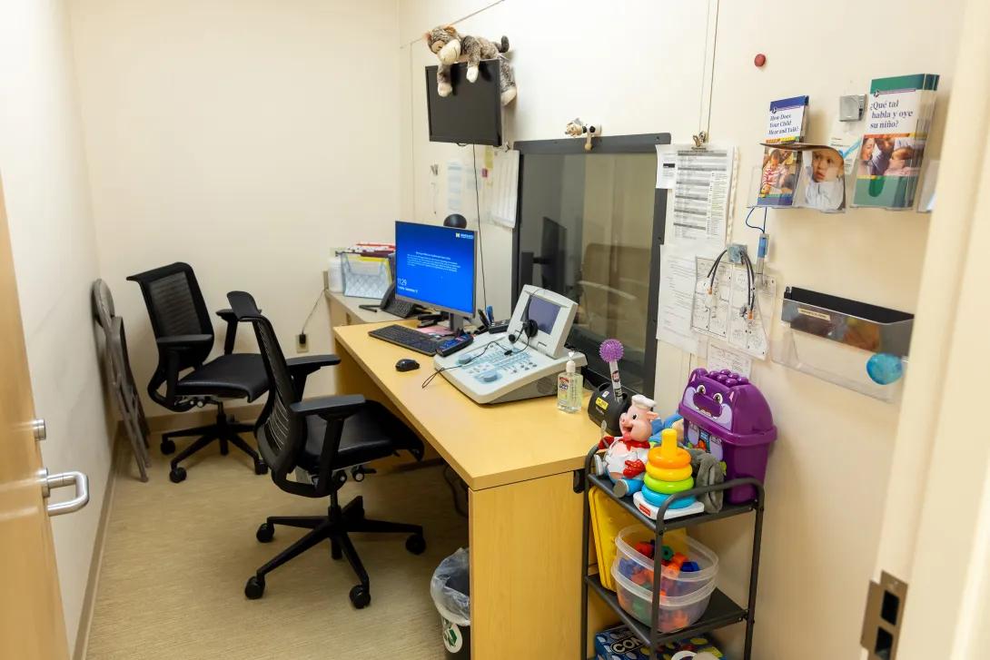 a peds clinic room with chairs and audiology equipment