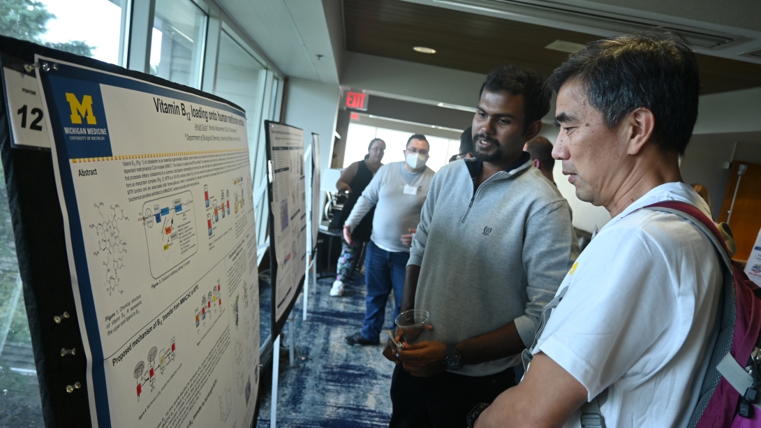 scientists discussing research at a poster session