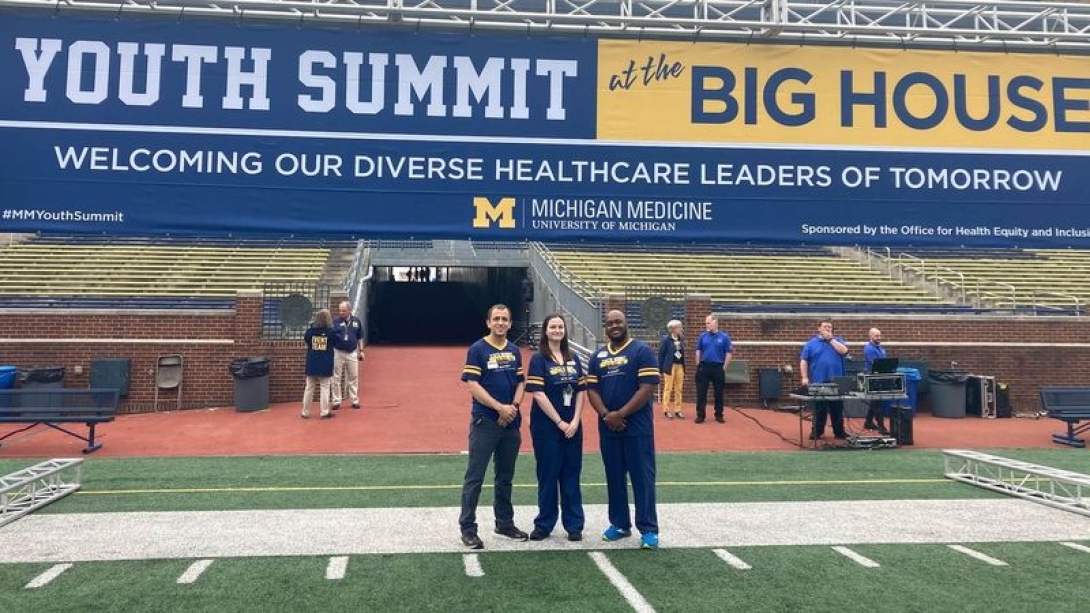 Three people standing on a football field