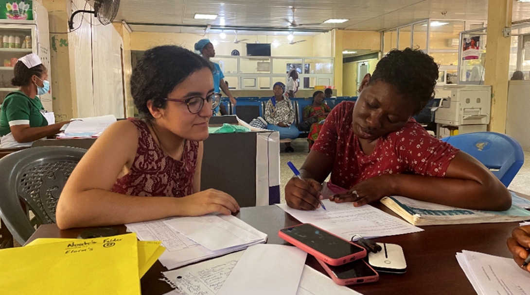 Two women sitting at table and looking over papers together