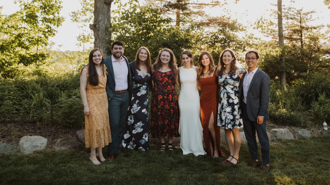 A cheerful gathering of Internal medicine med-peds class of 2024 resident graudates standing in front of a tree, all smiling for the camera.