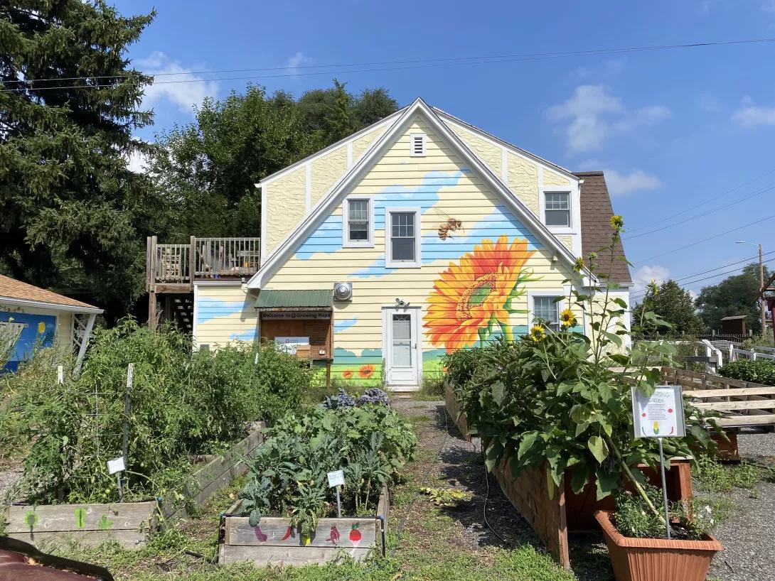 Growing Hope’s Ypsilanti urban farm, with a floral mural on a building