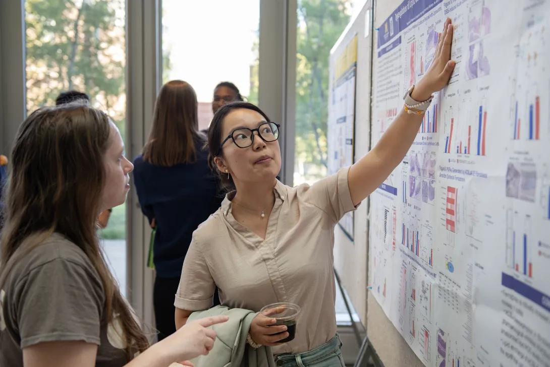 PhD students looking at a poster