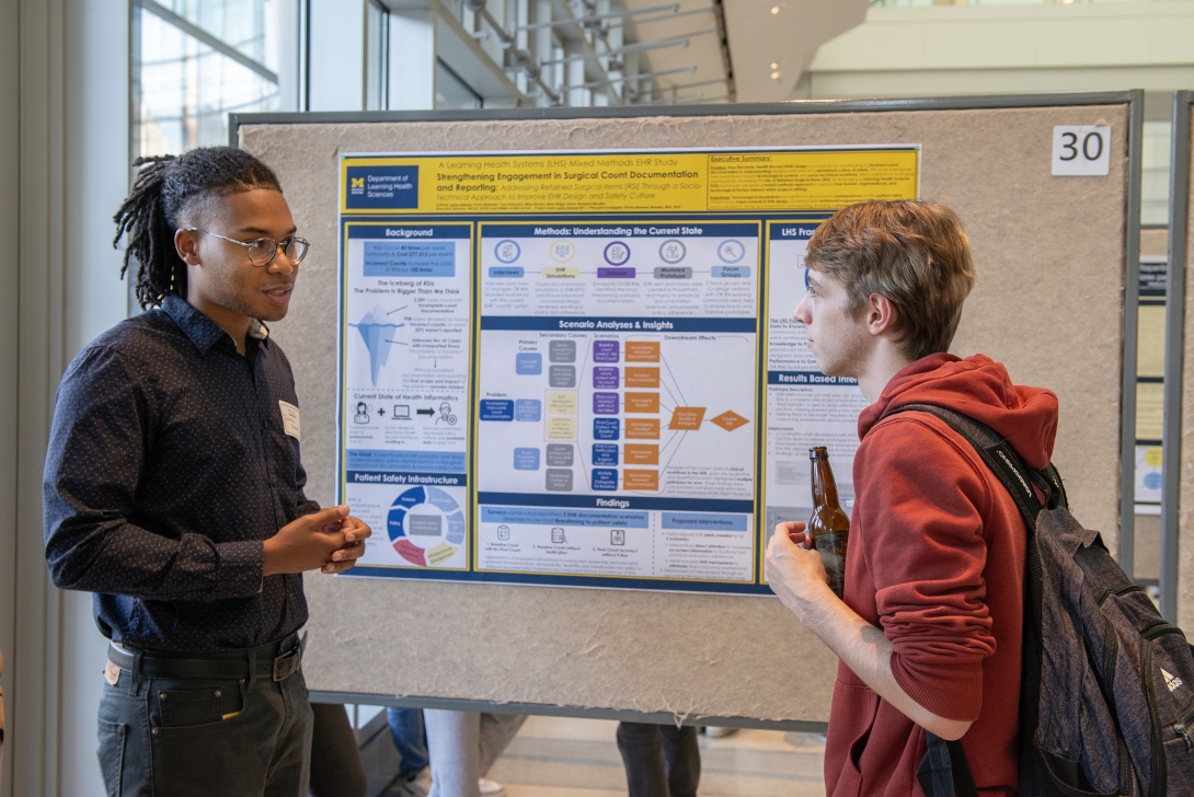 PhD students in front of a poster