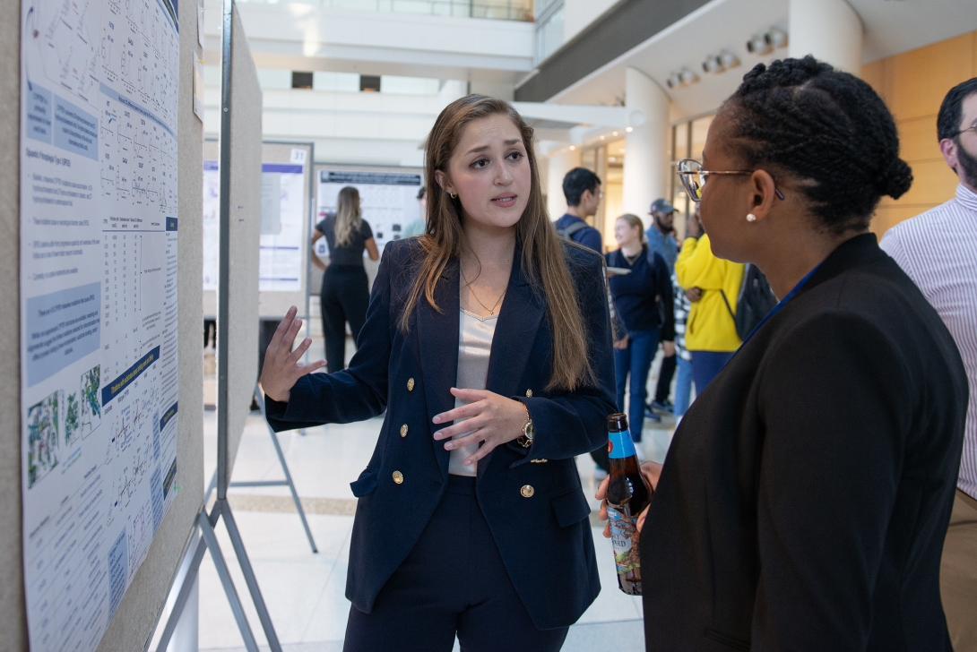 PhD students in front of a poster