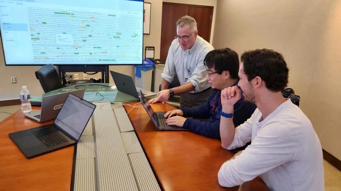 Dr. Hanauer and team in a conference room looking at laptops