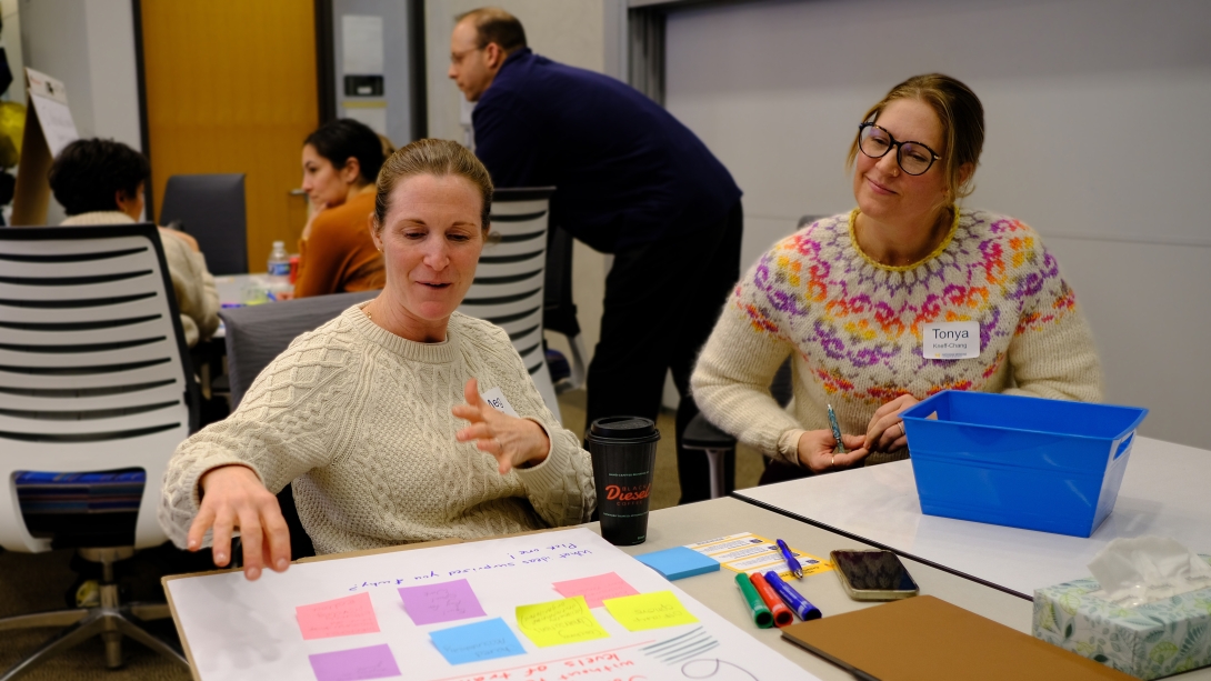 Attendees pin post its on their board