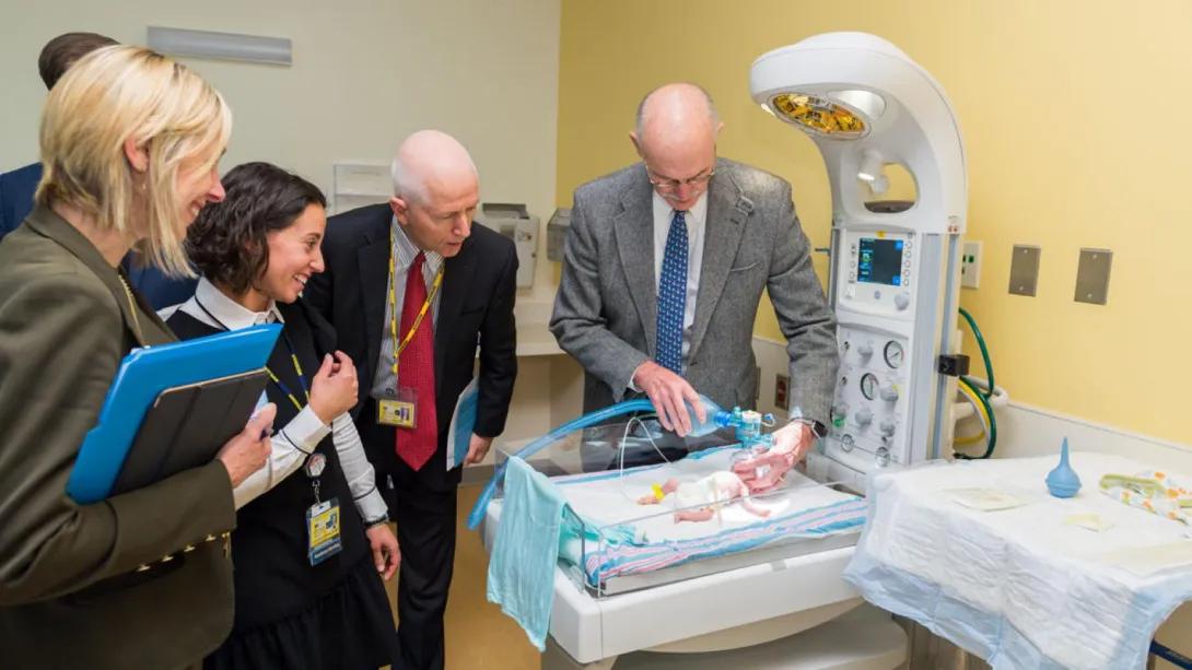 People working with a pediatric manikin