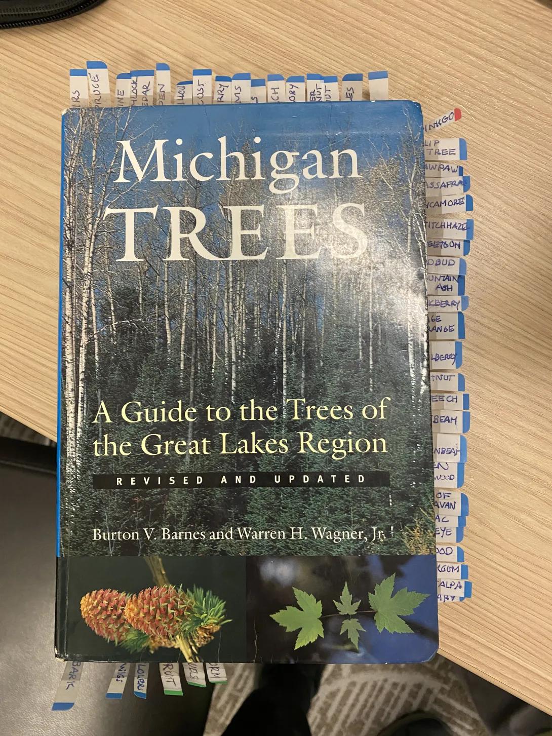 A book, "Michigan Trees," full of annotated tabs