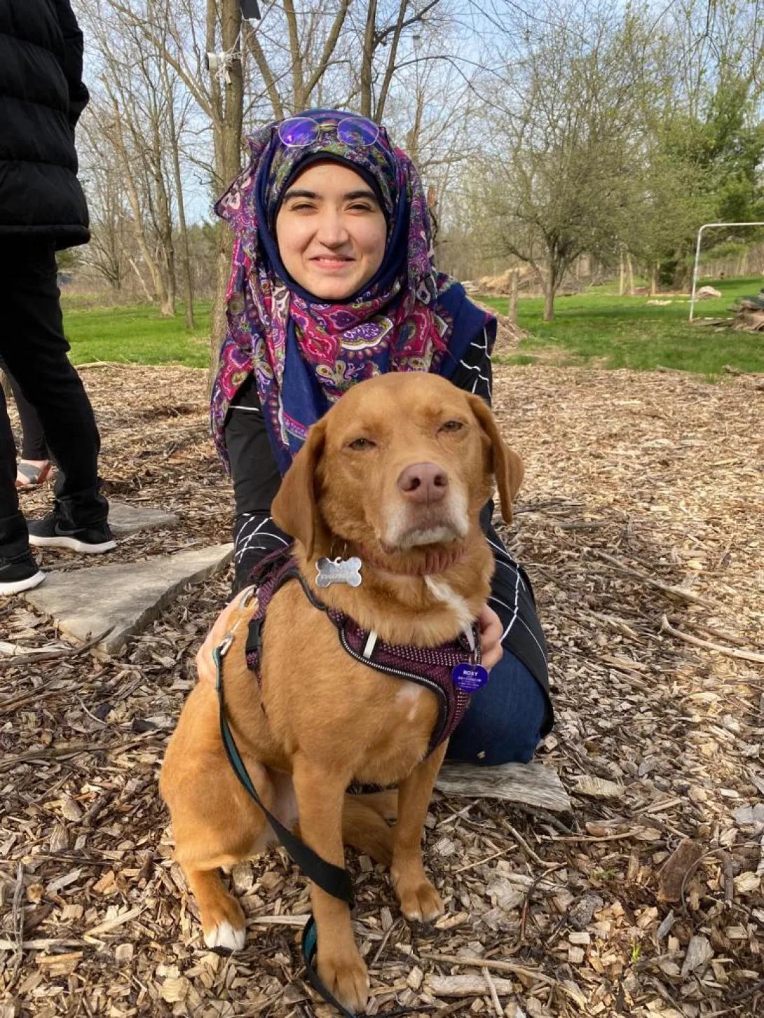 Mahnoor with a dog on a fall day