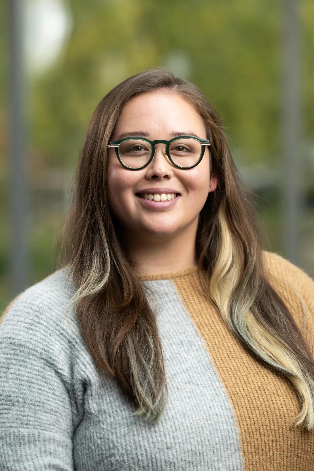 Smiling woman with long brown hair and glasses