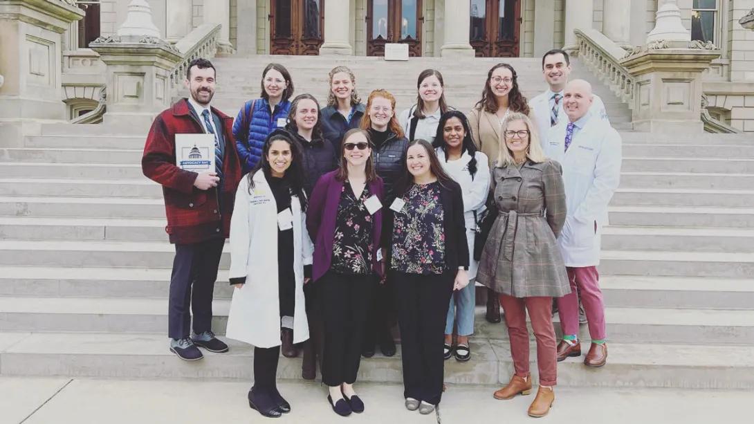 Family medicine affiliates pose for a group photo in front of a large building.