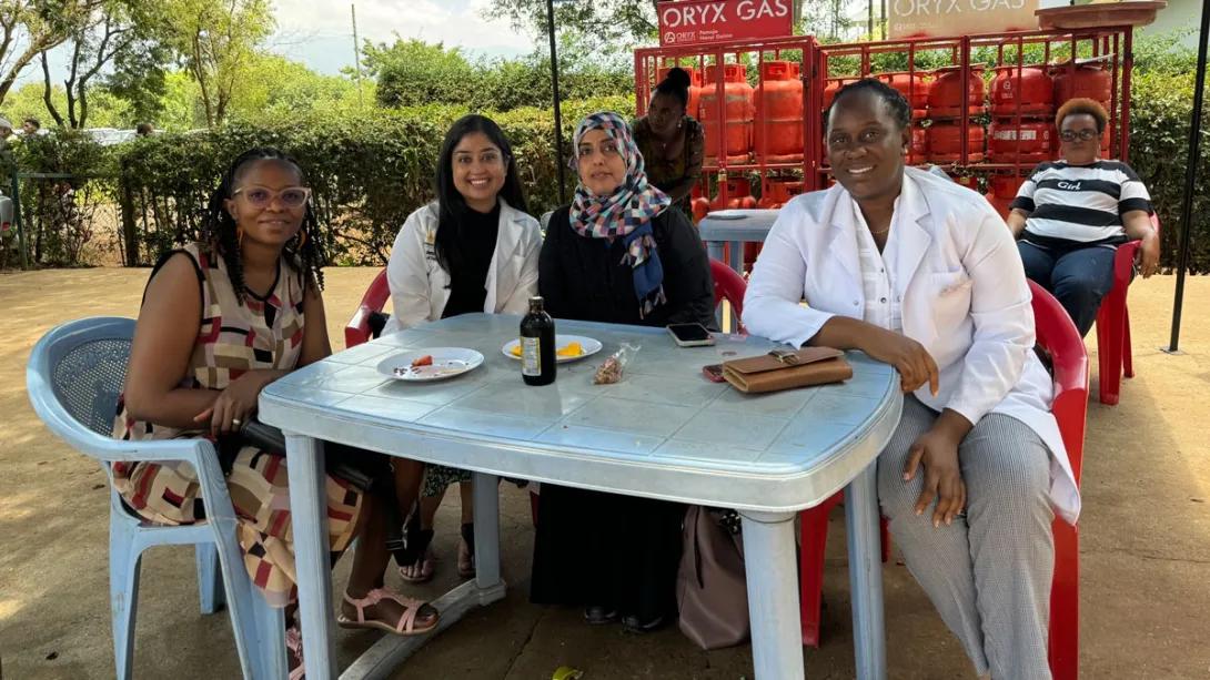 four women sit around a table 