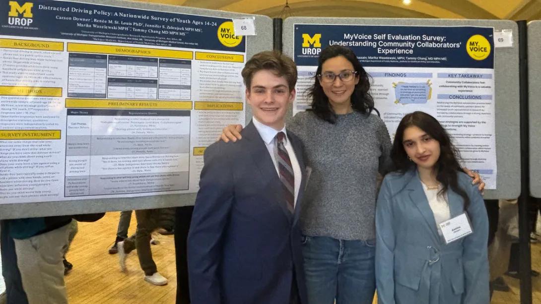 Three people standing in front of a my voice board
