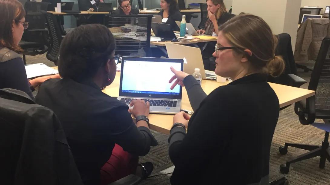 One person guides another on a laptop screen