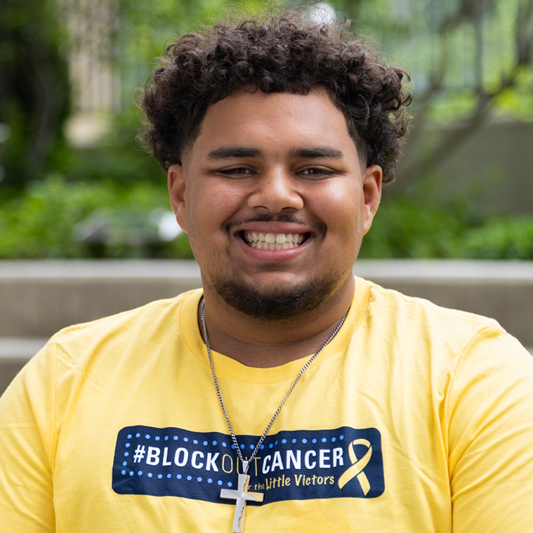 Smiling photo of a young man wearing a Block Out Cancer t-shirt.