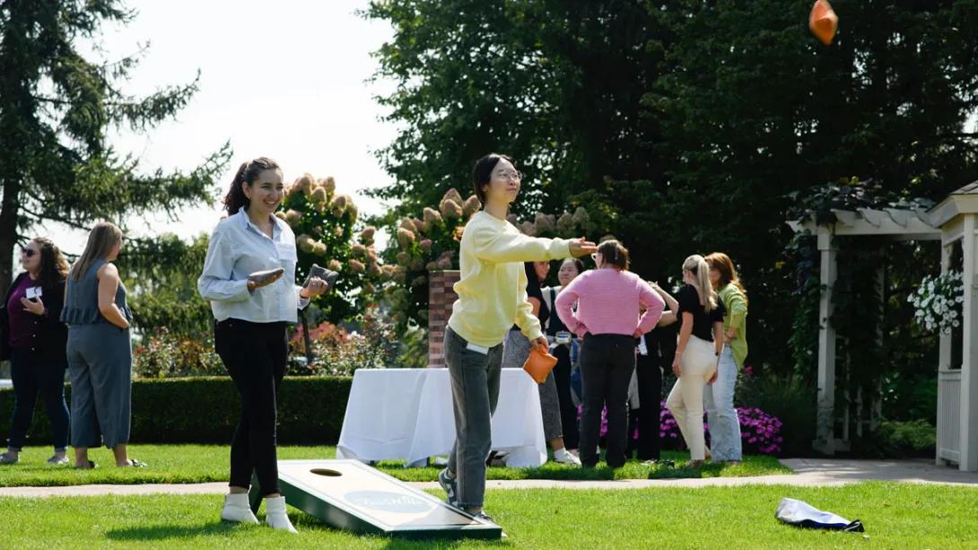 A few female researchers play bags game at the outdoor retreat