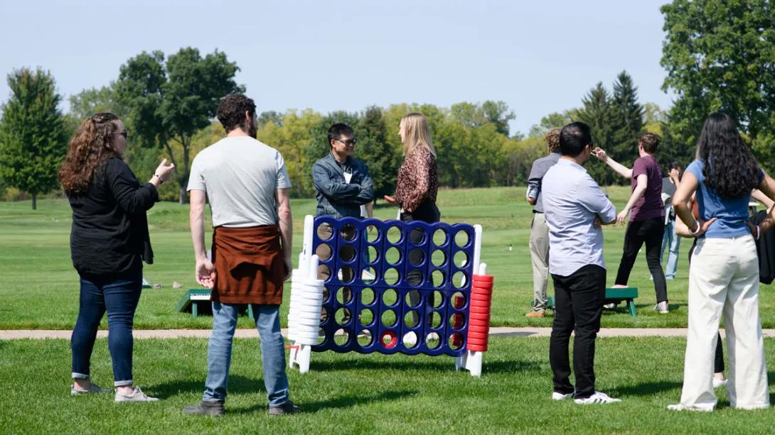 A group of researchers play connect 4 at the outdoor retreat