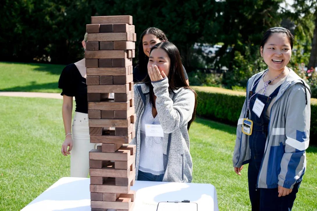 A group of students playing the board game Jenga