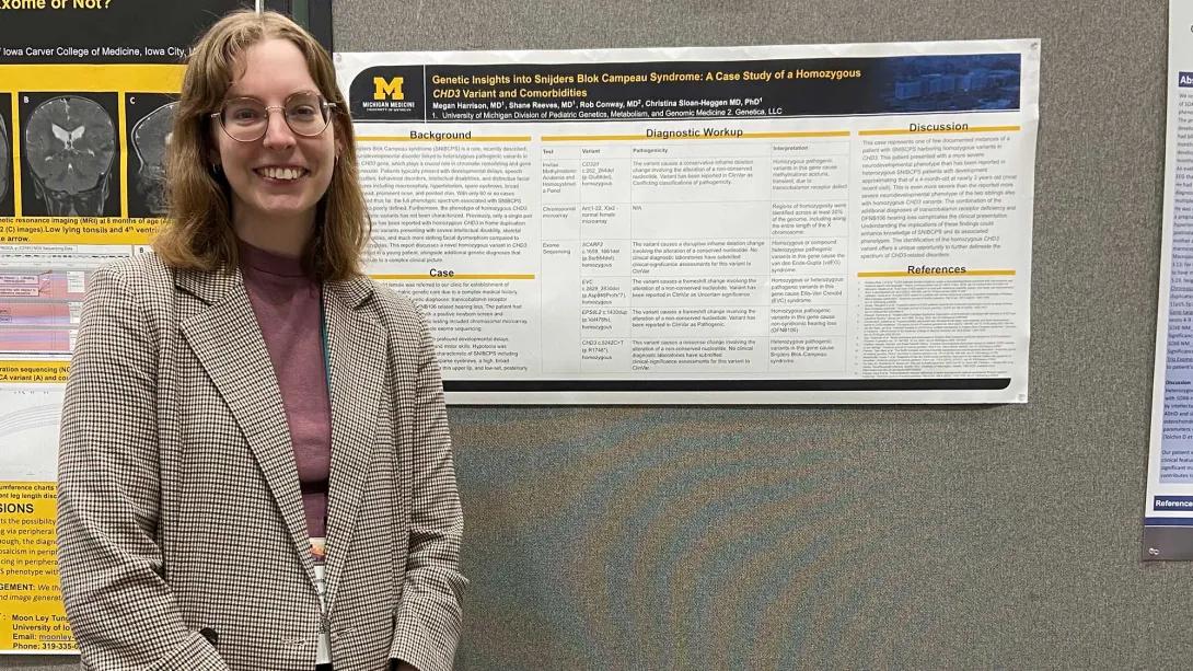 Pediatrics medical genetics team members standing by research poster