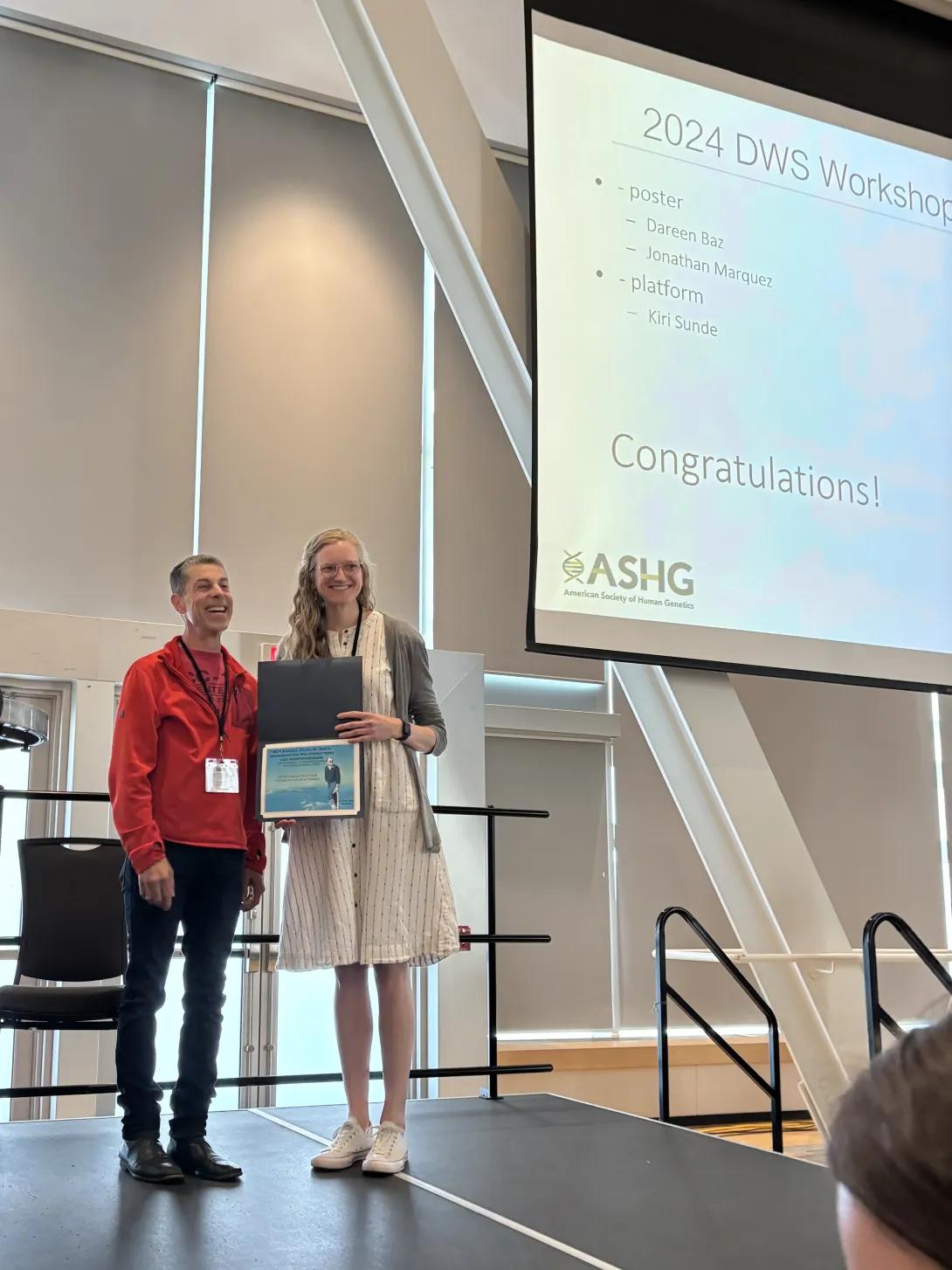 Kiri Sunde accepting an award at a workshop on stage