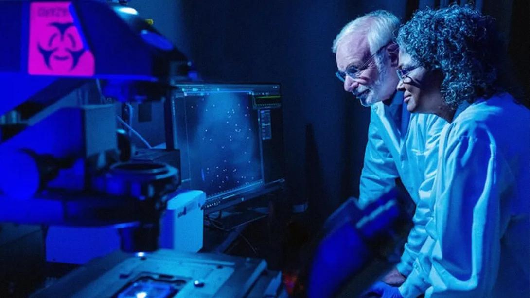 two scientists in lab dark glowing