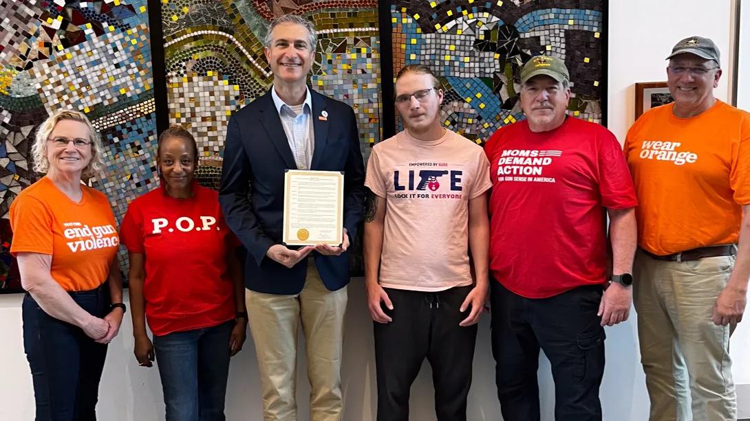 people standing in red and pink and orange shirts with Ann Arbor mayor