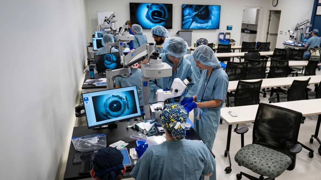 Residents practice ophthalmic surgical techniques using microscopes in the wet lab.