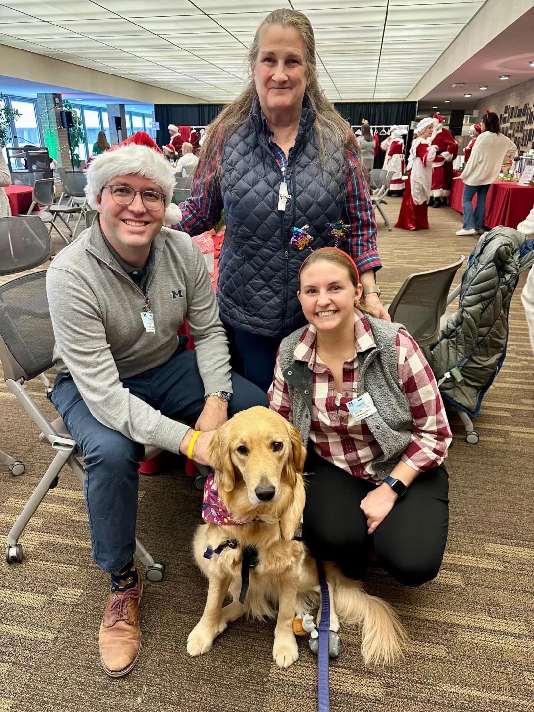 Kyle, Kathy, Alyssa Cozad with a therapy dog on Santa Day
