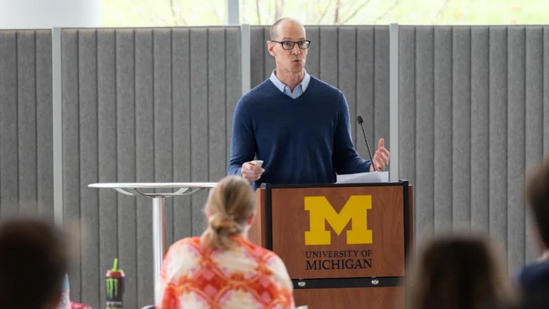 A presenter speaks from a University of Michigan podium to attendees during the Department of Anesthesiology Research Retreat.