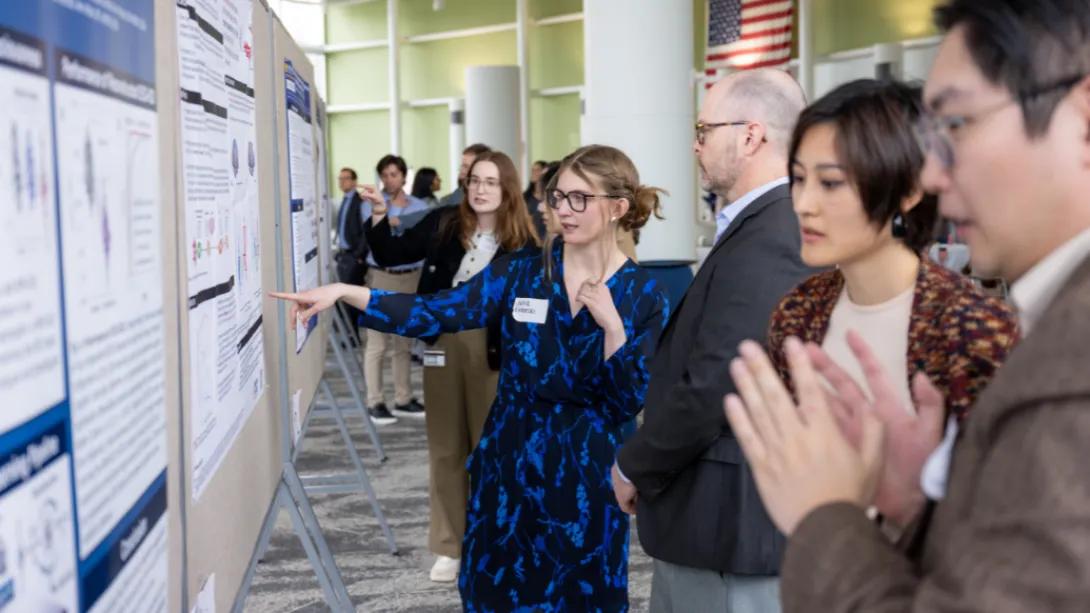 Attendees view and discuss research posters during the Department of Anesthesiology Research Retreat poster session.