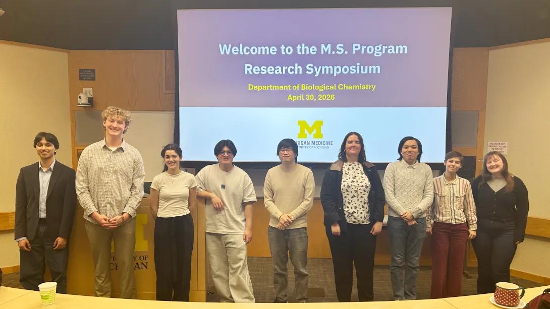 9 students at the front of an auditorium