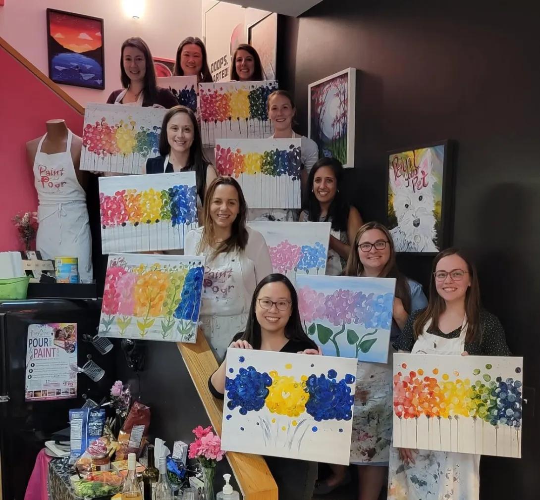 Hospital medicine fellows painting canvases during a painting class.