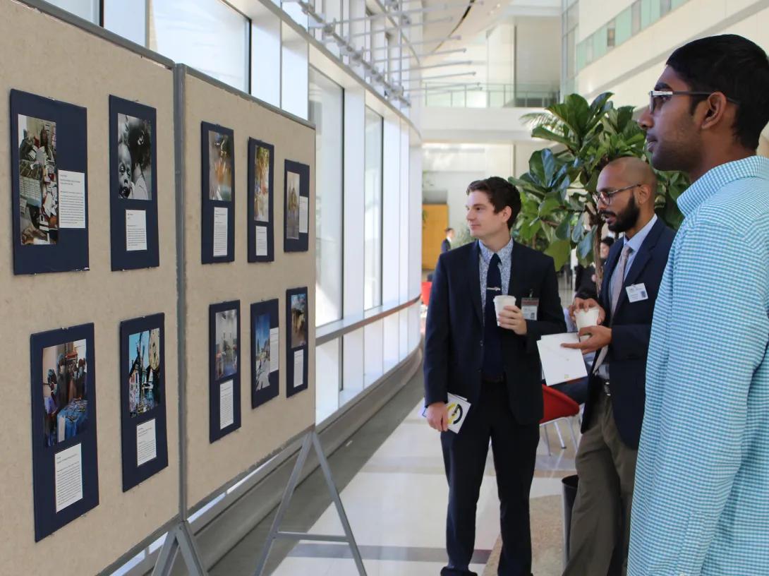 attendees looking at a global health photo display